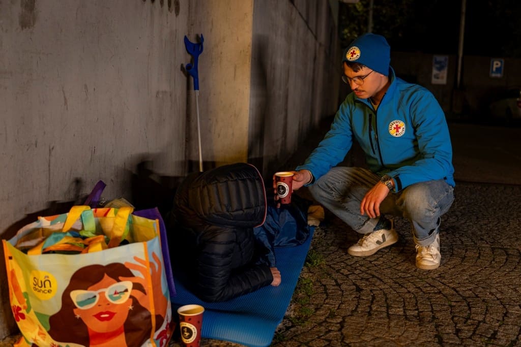 Mitarbeiter der Bahnhofsmission Würzburg hilft einem Obdachlosen