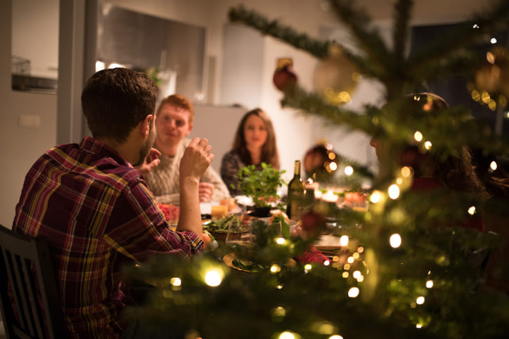 Freunde sitzen an Weihnachten gemütlich beim Weihnachtsdinner in Würzburg
